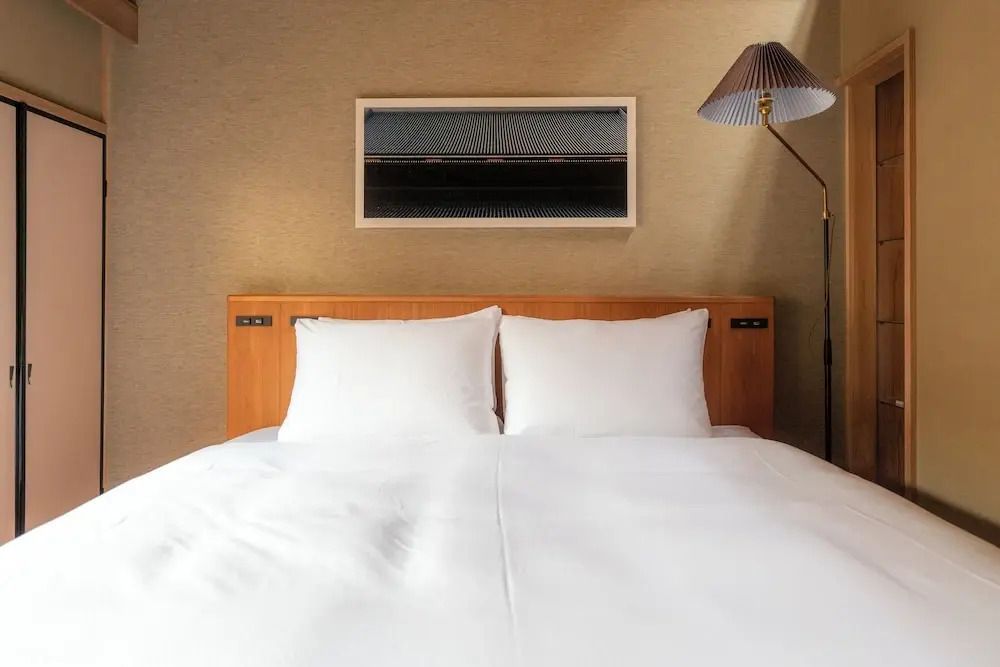 Modernes Schlafzimmer mit Doppelbett und stilvoller Beleuchtung