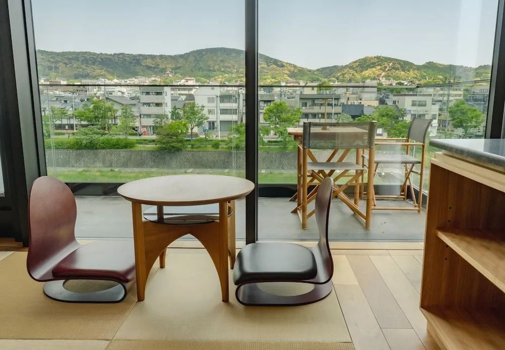 Zimmer mit traditionellem japanischen Tisch und Stühlen mit Blick auf die Berge