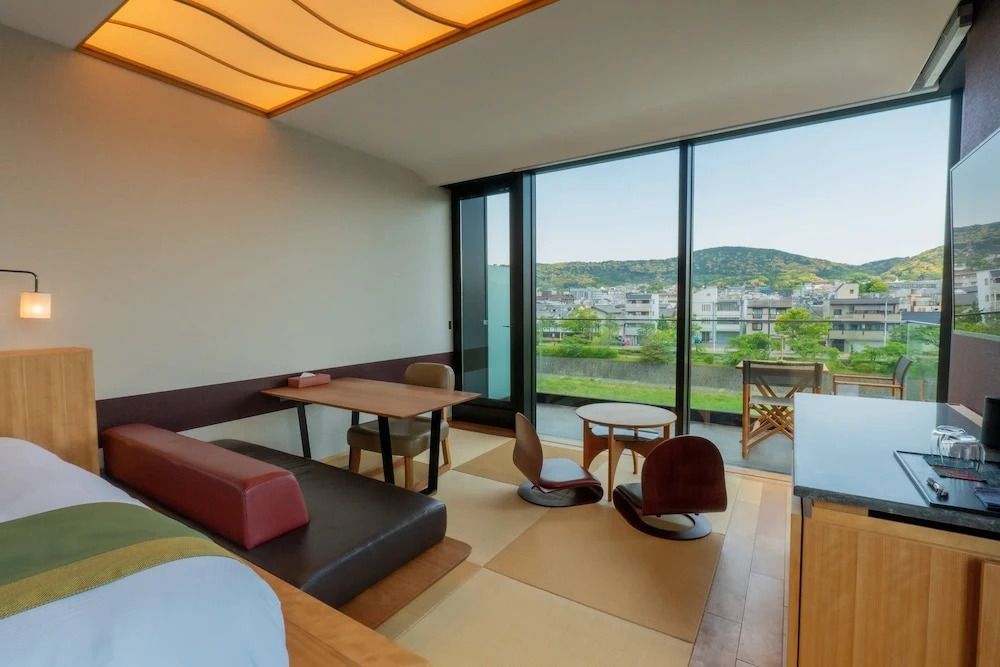 Zimmer mit Sitzbereich und großer Fensterfront mit Bergsicht