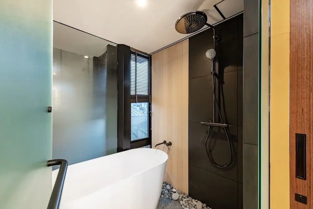 Geräumiges Badezimmer mit freistehender Badewanne und Regendusche
