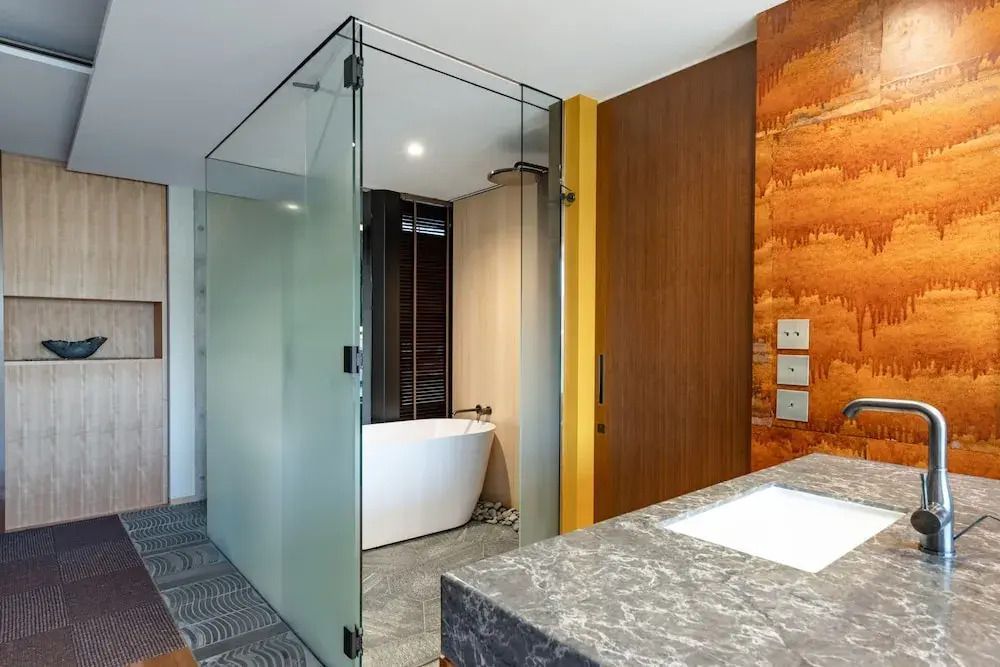 Modernes Badezimmer mit gläserner Duschabtrennung und edlem Waschbecken