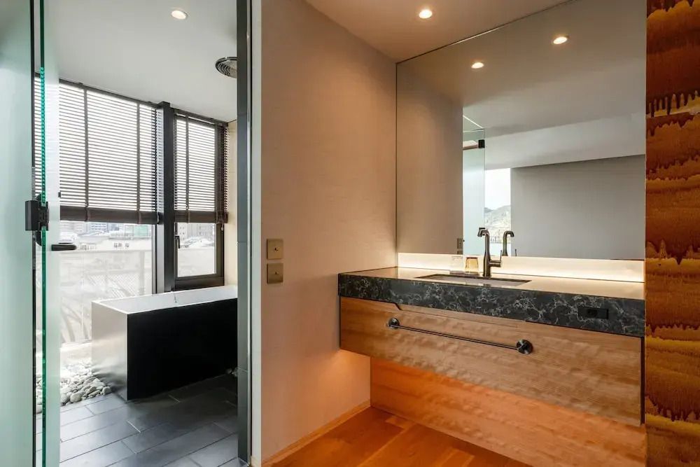 Luxuriöses Badezimmer mit modernem Waschtisch und großem Fenster.