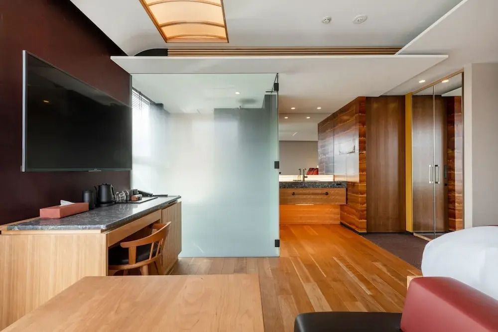 Zimmer mit offenem Grundriss, moderner Küchenzeile und Holzmöbeln.