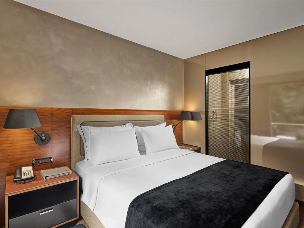 Schickes Doppelbett mit dezenter Beleuchtung und Holzdetails im Zimmer.