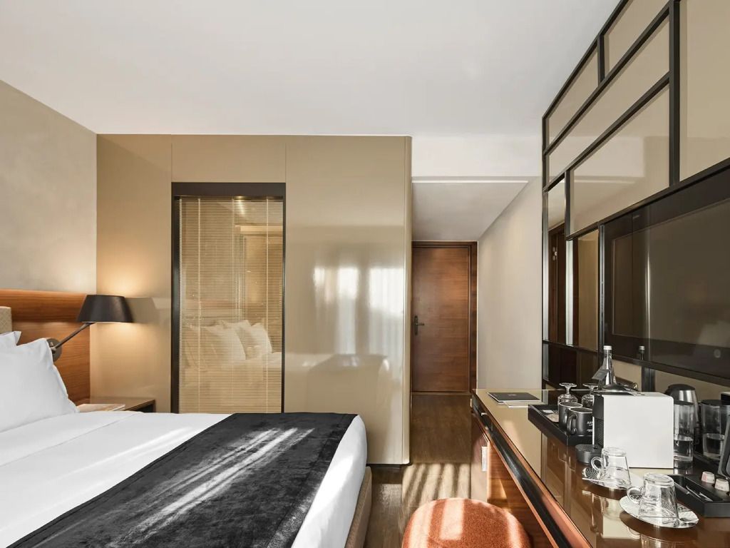 Geräumiges Deluxe-Zimmer mit Spiegel und edlen Design-Elementen.