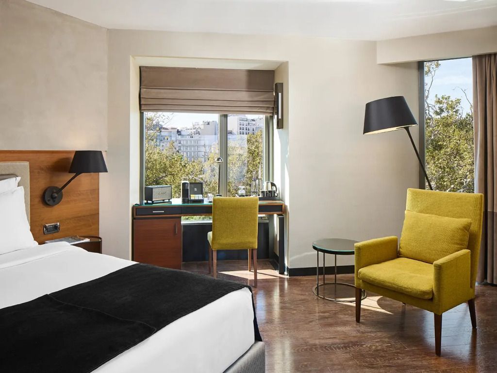 Schreibbereich und gemütlicher Sitzbereich in der Junior-Suite mit großer Fensterfront