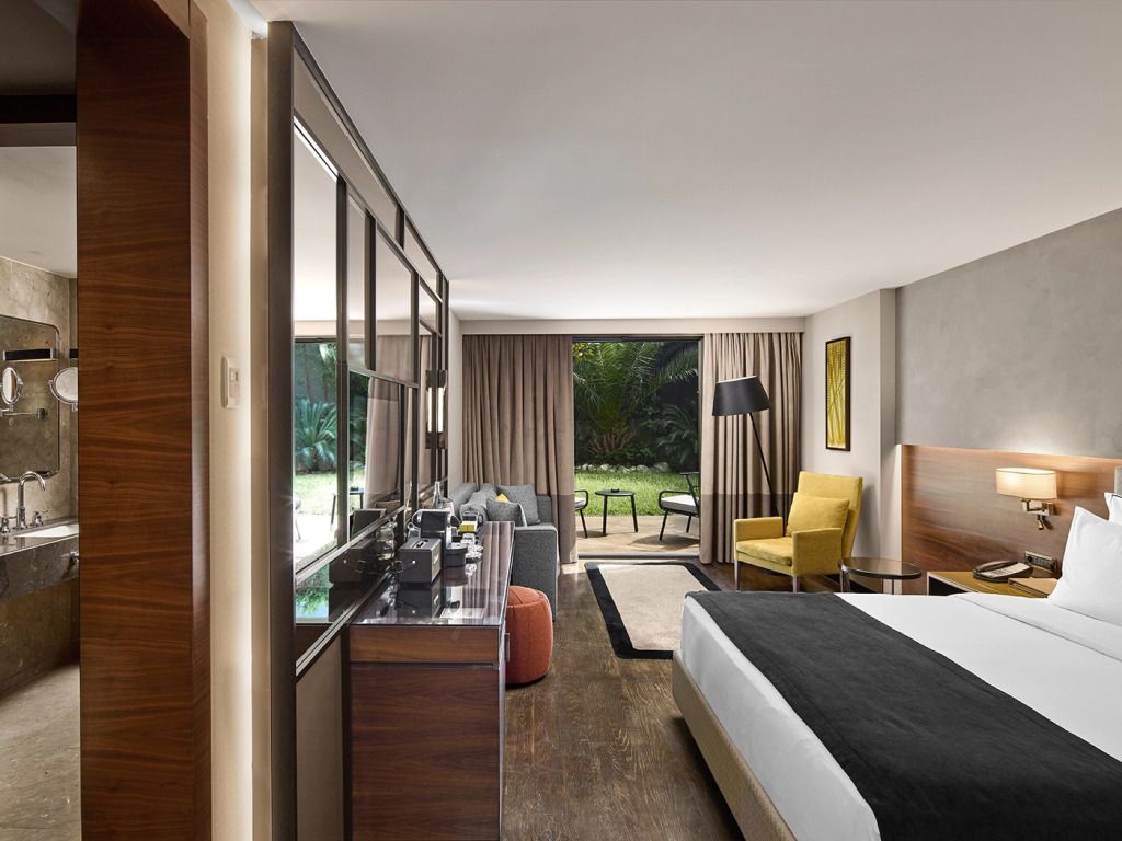 Moderner Hotelzimmer mit Doppelbett, Gartenblick und stilvollem Interieur