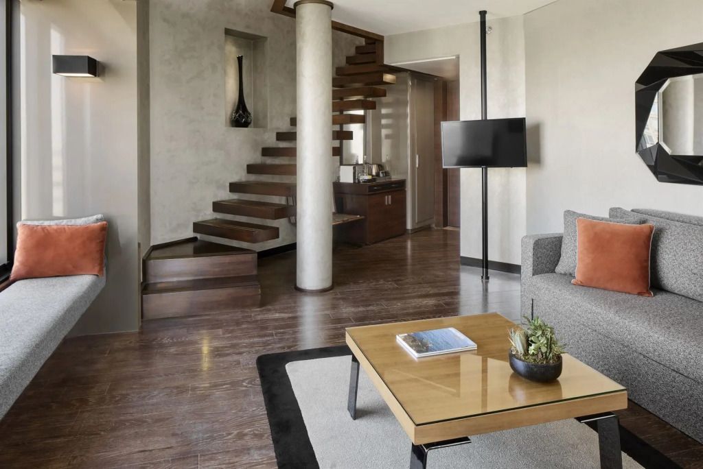 Wohnbereich der Suite mit Treppe, Flachbildfernseher und stilvollem Interieur