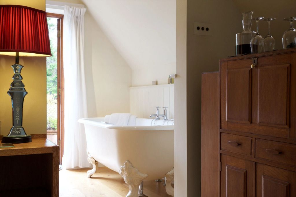 Elegante freistehende Badewanne in einem stilvollen Hotelzimmer mit Holzakzenten
