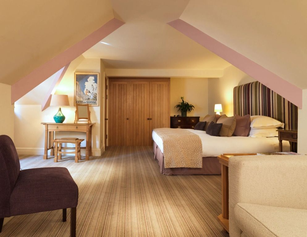 Großzügiges Schlafzimmer mit Schrägwänden und Doppelbett in der Familie Loft Suite