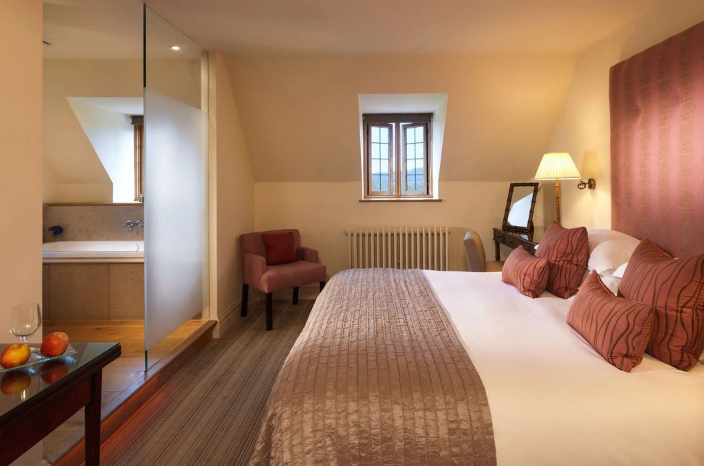 Schlafzimmer mit Bett, Sessel und verspiegeltem Frisiertisch