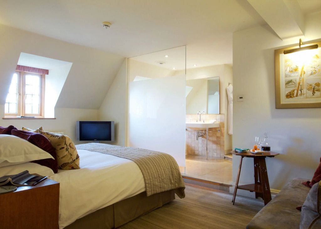 Helles Zimmer mit Bett und moderner Badausstattung