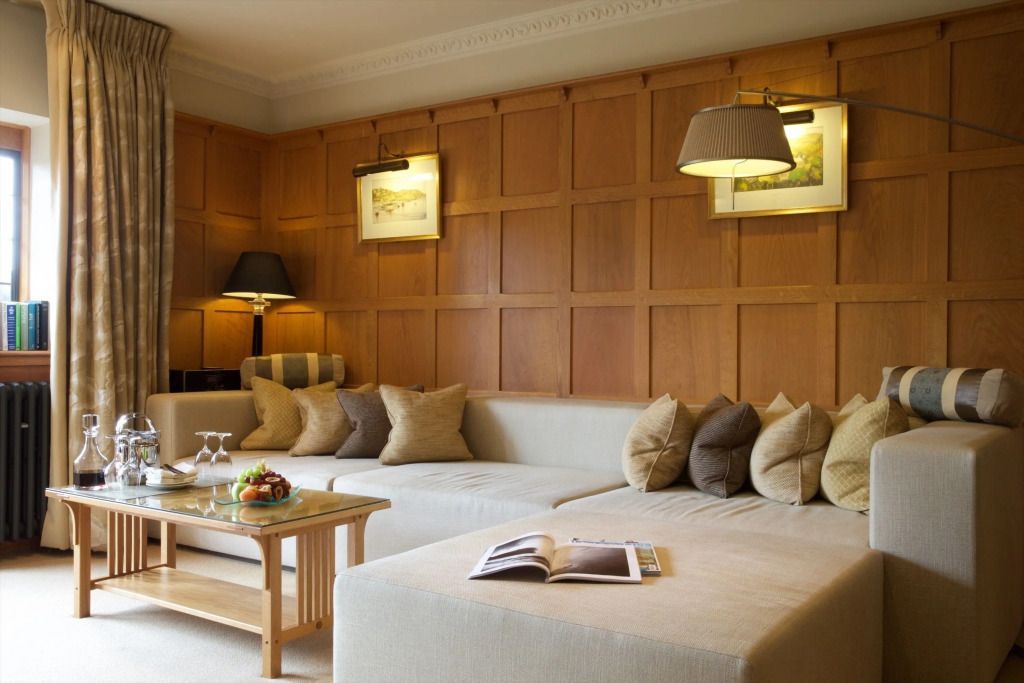 Sitzecke mit Kissen und stilvollem Holzwanddesign in der Spa Suite