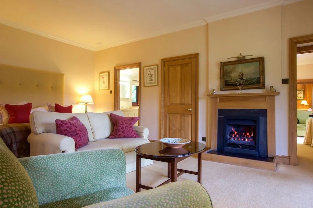 Wohnzimmer mit Kamin, Sofa und luxuriöser Einrichtung im klassischen Stil.