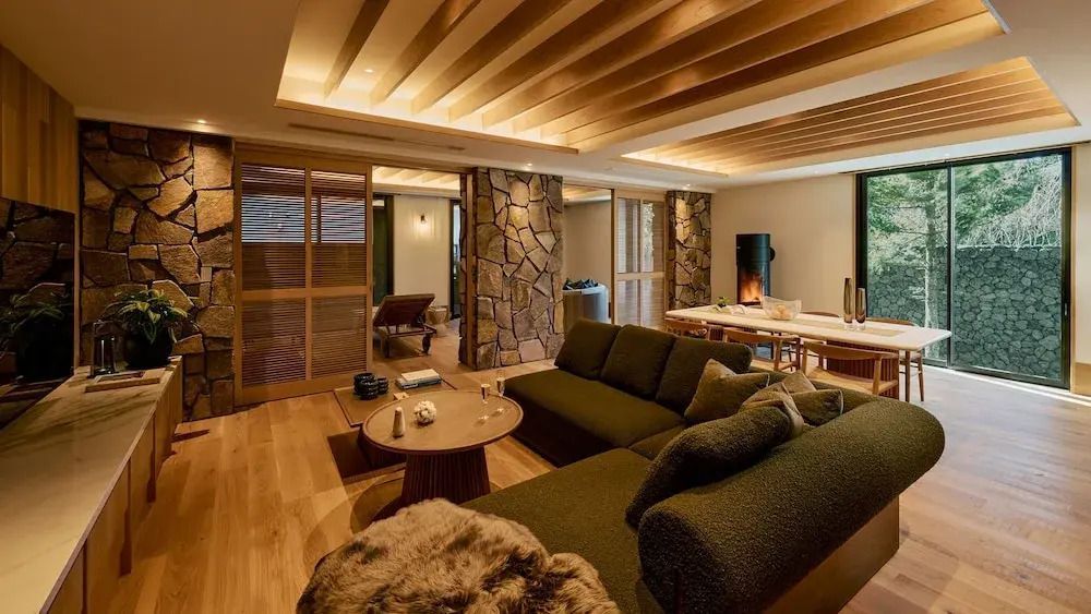 Elegantes Wohnzimmer in einer Luxusvilla mit gemütlichen Möbeln und Holzakzenten.