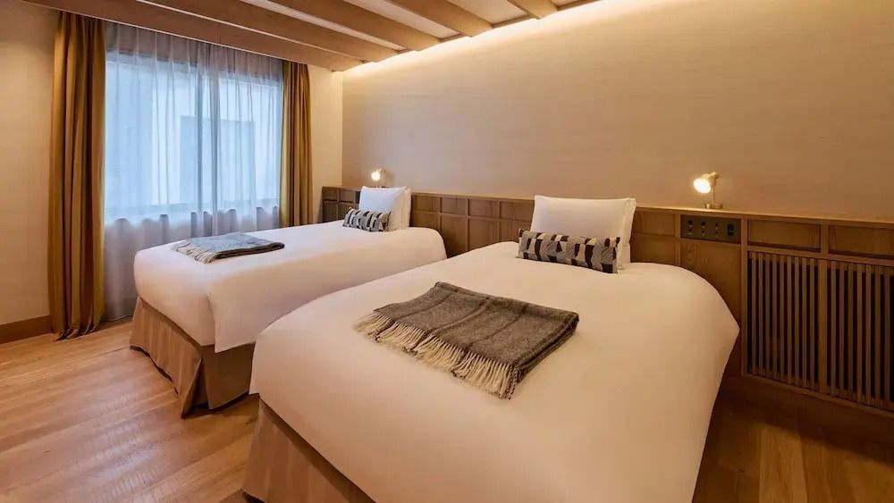 Zwei komfortable Einzelbetten in einem modernen, warm beleuchteten Schlafzimmer.