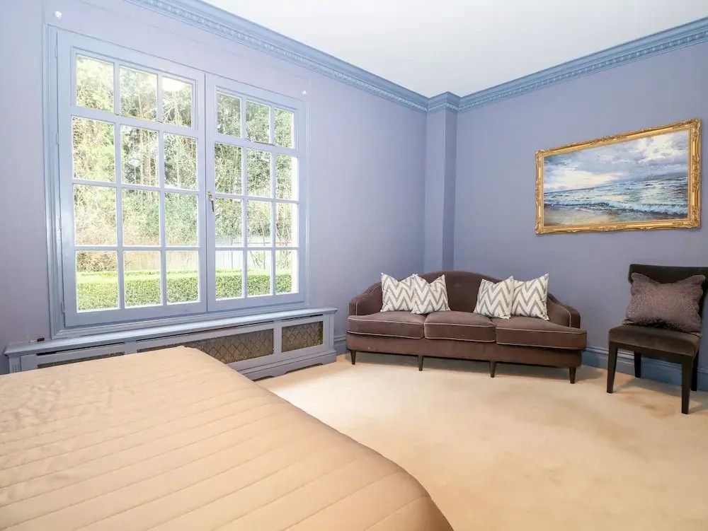Helles Schlafzimmer mit großem Fenster und Sofa im Gleneagles Hotel
