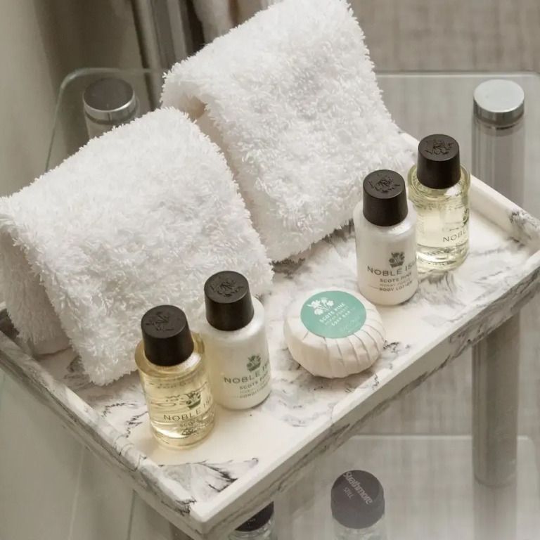 Badezimmeraccessoires mit luxuriösen Pflegeprodukten auf einem Marmorablage
