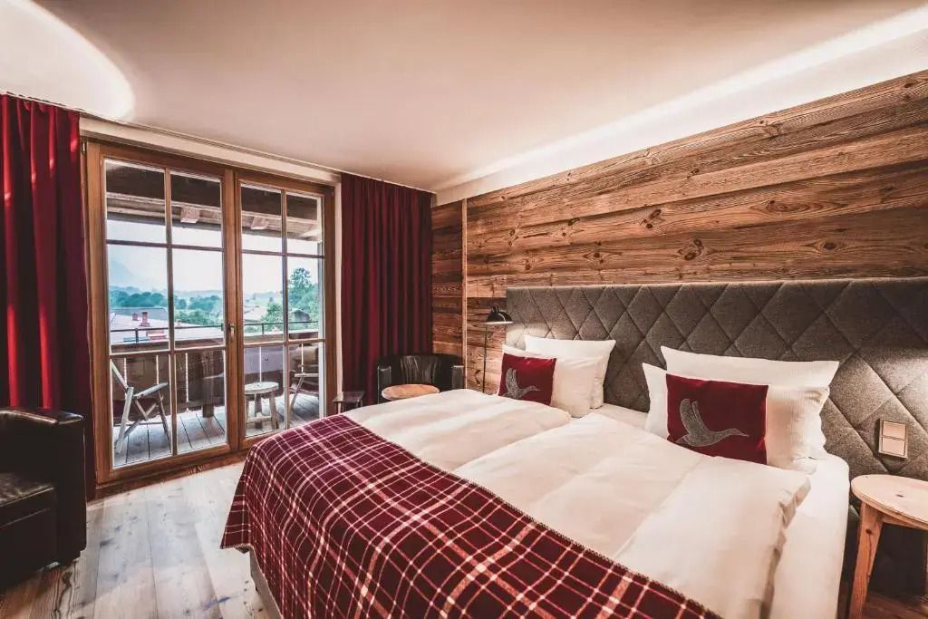 Elegantes Zimmer mit Holzwand und Zugang zum Balkon.