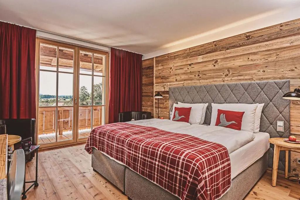 Helles Zimmer mit gemütlichem Doppelbett und Balkon.