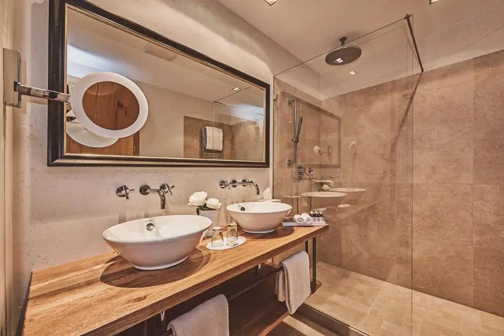Modernes Badezimmer mit Doppelwaschbecken und Glasdusche.
