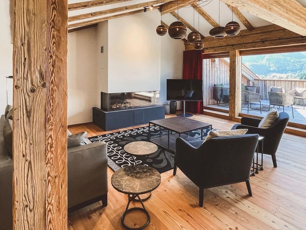 Wohnbereich mit Kamin und Balkonzugang in einer luxuriösen Suite