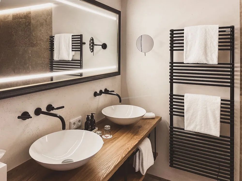 Modernes Badezimmer mit Doppelwaschbecken und stilvoller Holzablage.