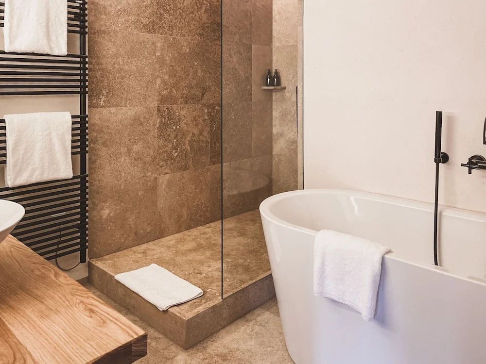 Luxuriöses Badezimmer mit freistehender Badewanne und ebenerdiger Dusche.