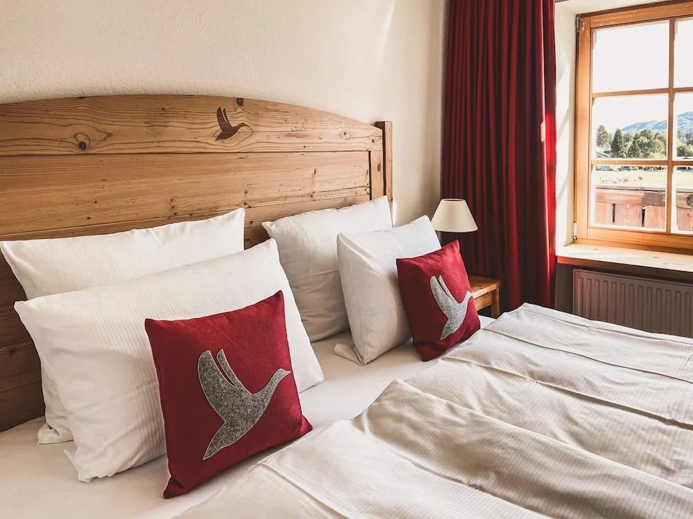 Doppelbett mit roten Dekokissen im Hotel Das Achental