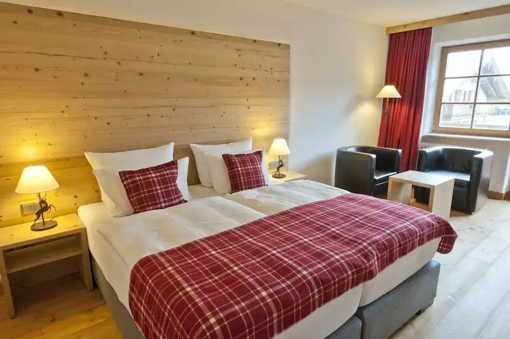 Doppelzimmer mit Holzakzenten und roten Vorhängen