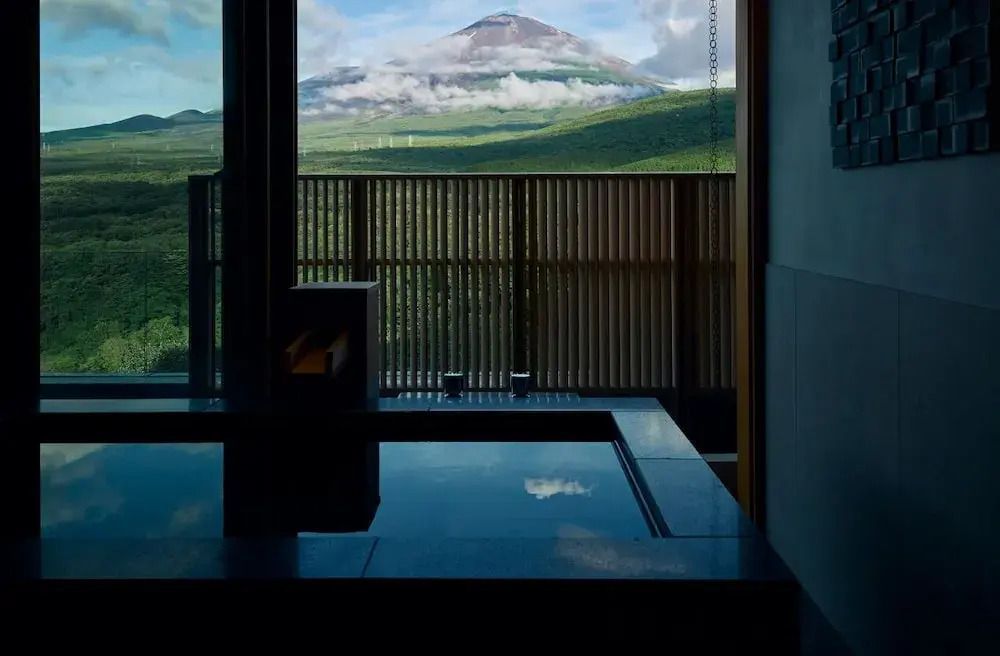 Blick von einer Suite auf den Vulkan Fuji mit großen Fenstern und einem eleganten Indoor-Pool