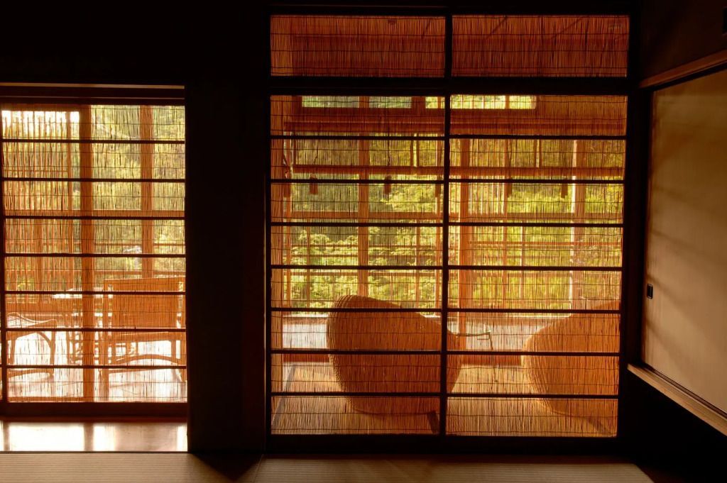 Traditionelle japanische Einrichtung mit Fensterfront und Blick ins Grüne.