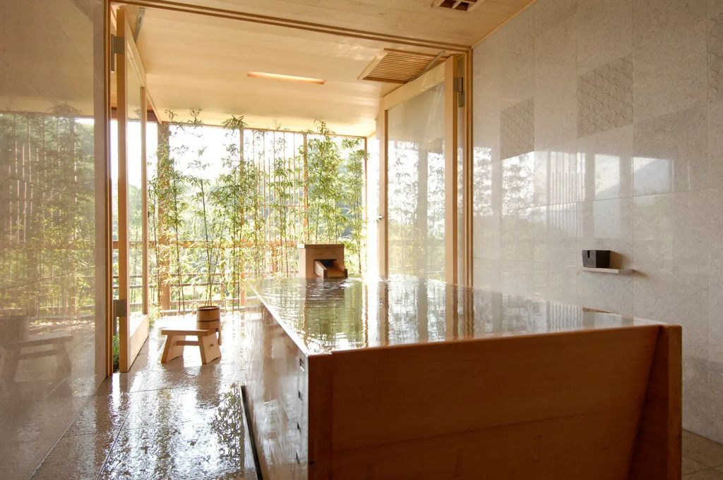 Minimalistisches Spa mit Holzbadewanne und Ausblick auf Bambusgarten.