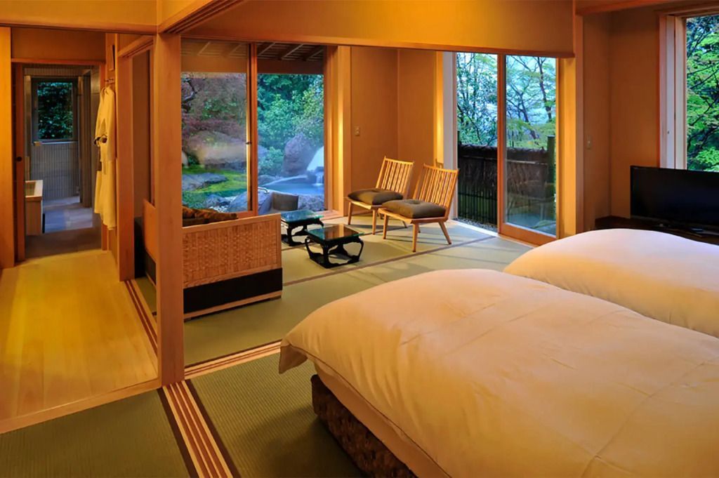 Japanische Suite mit Tatamimatten und Blick auf einen privaten Garten.