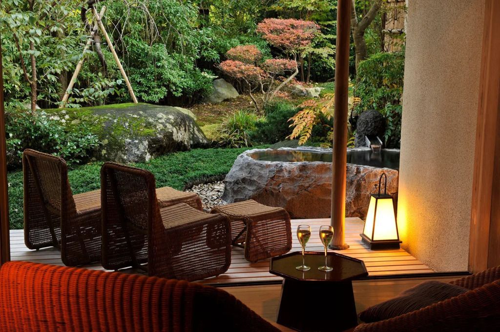 Terrasse mit Blick auf einen gepflegten Garten und zwei gefüllte Champagnergläser
