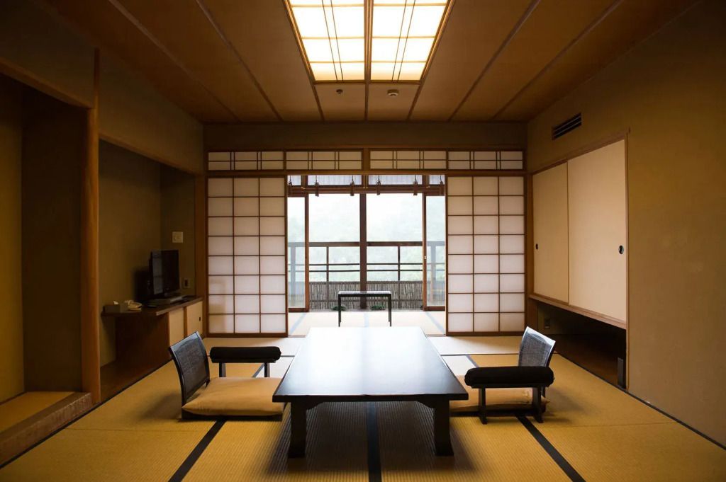 Traditionell eingerichtetes japanisches Zimmer mit Tatami-Boden und Schiebetüren.