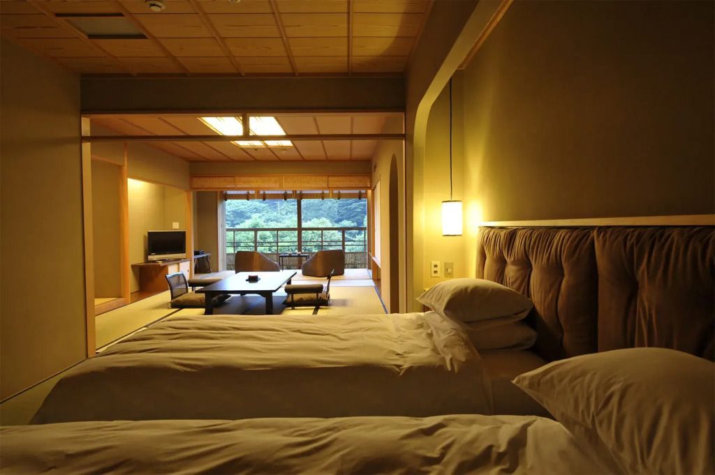 Elegante Suite mit Tatami-Matten, Doppelbetten und großem Fenster mit Naturblick.