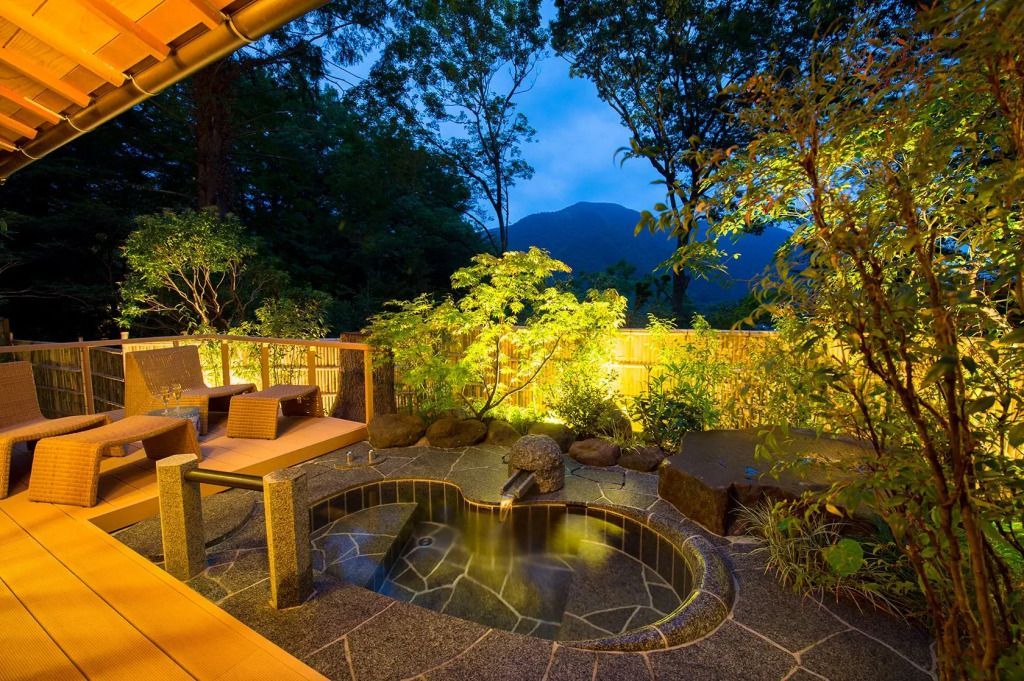 Private Onsen-Thermalquelle im Freien mit Blick auf die Berge und Bäume