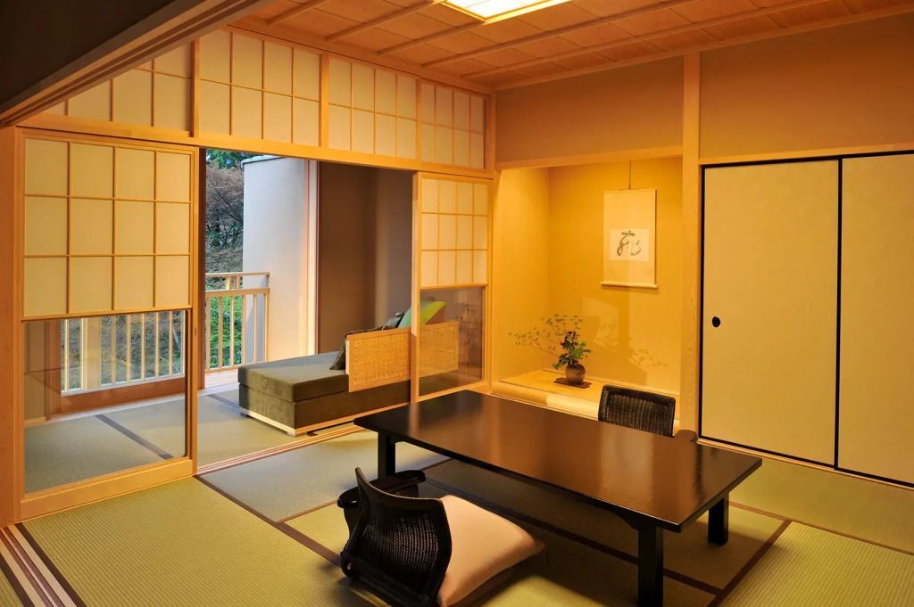 Japanische Teestube mit Schiebewänden und Bonsai in ruhiger Atmosphäre.