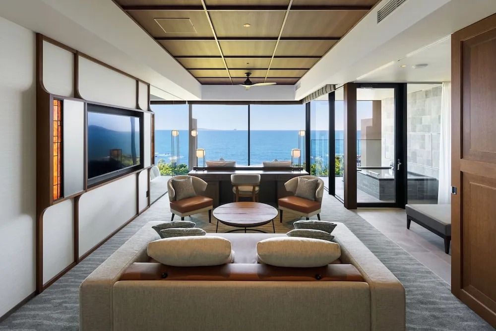 Luxuriöser Wohnbereich mit Sofa und Meerblick durch große Fenster