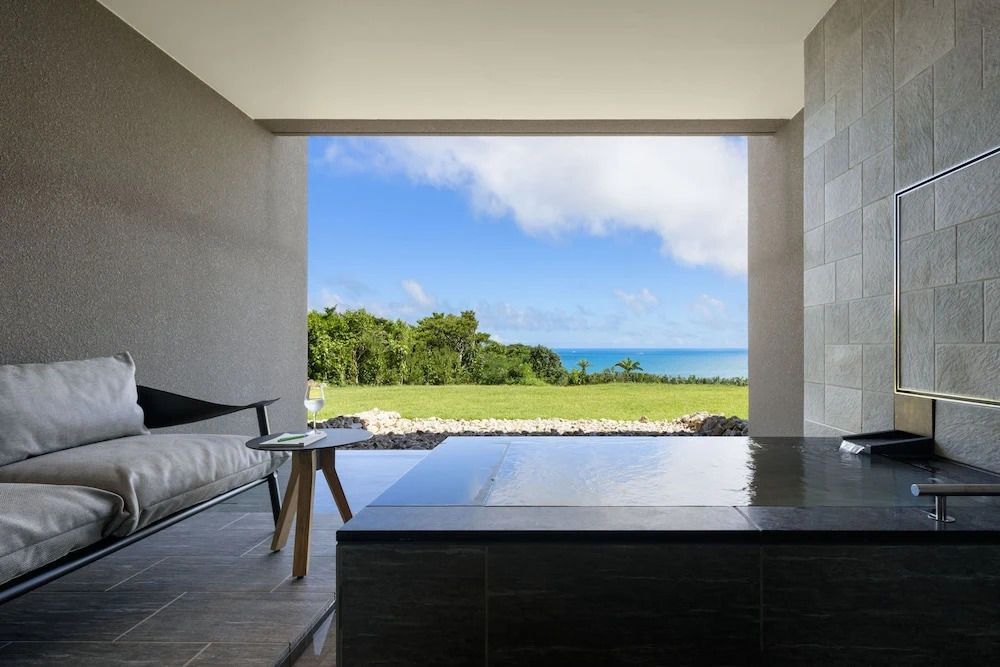 Terrasse mit Whirlpool und Blick aufs Meer und grüne Wiese
