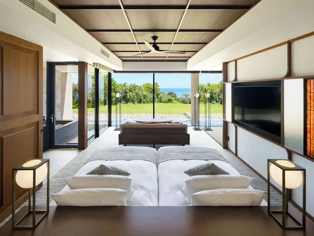 Elegantes Doppelzimmer mit zwei Einzelbetten und Meerblick durch große Fenster