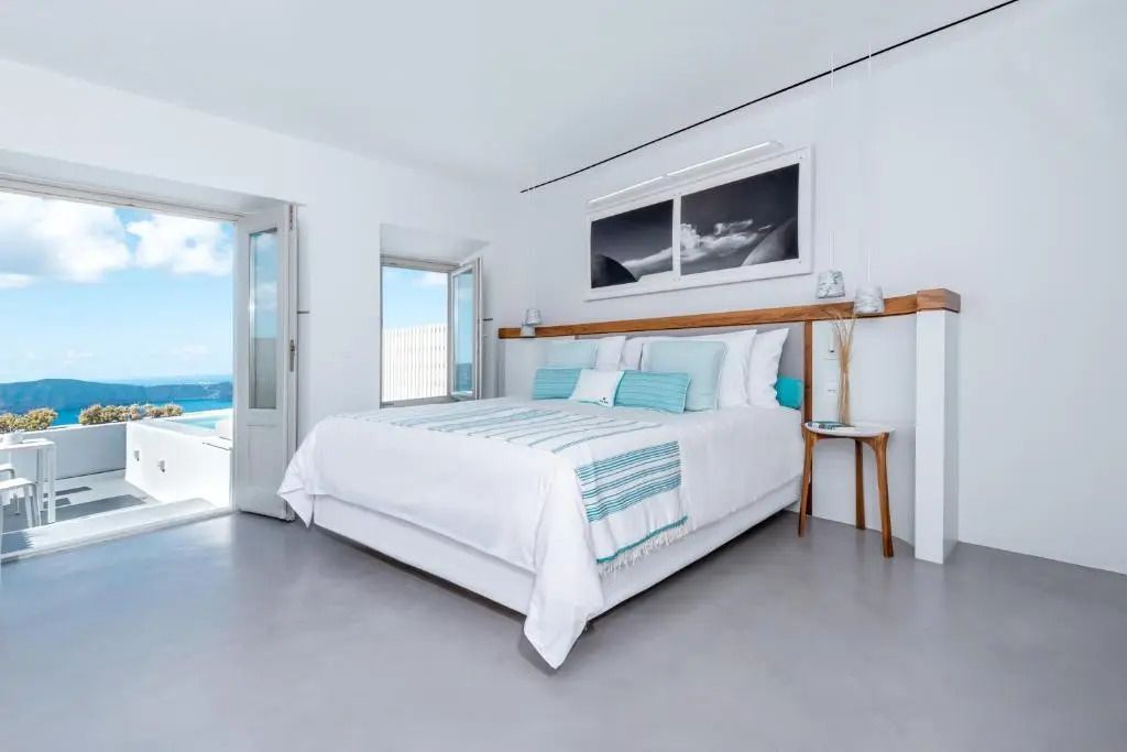 Großes gemütliches Bett in einem schlichten, eleganten Zimmer mit Wandkunst