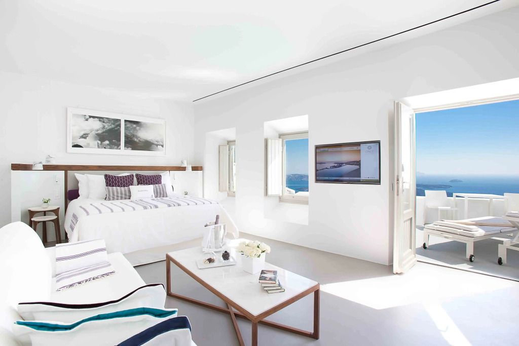 Zimmeransicht mit großem Bett, Fernseher und Balkonblick