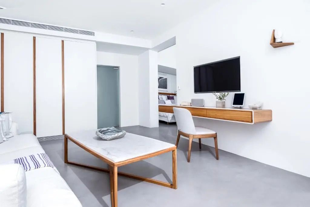 Minimalistisches Schlafzimmer mit großem Flachbildfernseher und Schreibtisch