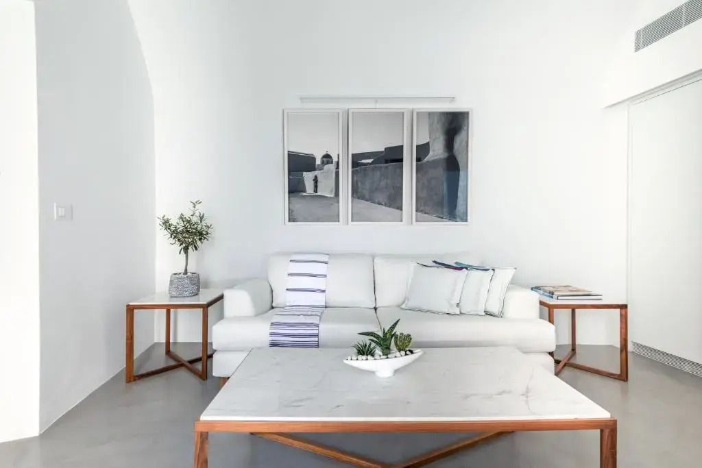 Wohnzimmer mit weißem Sofa und stilvollen Kunstwerken an der Wand