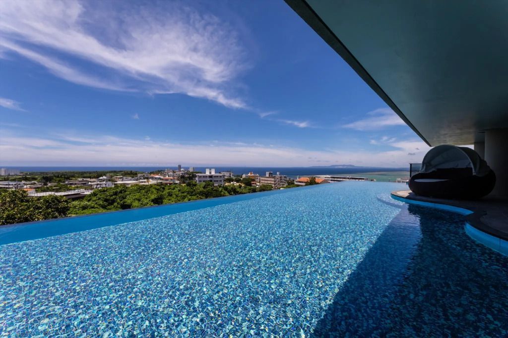 Infinity Pool mit Blick auf die Stadt und das Meer bei klarem Himmel