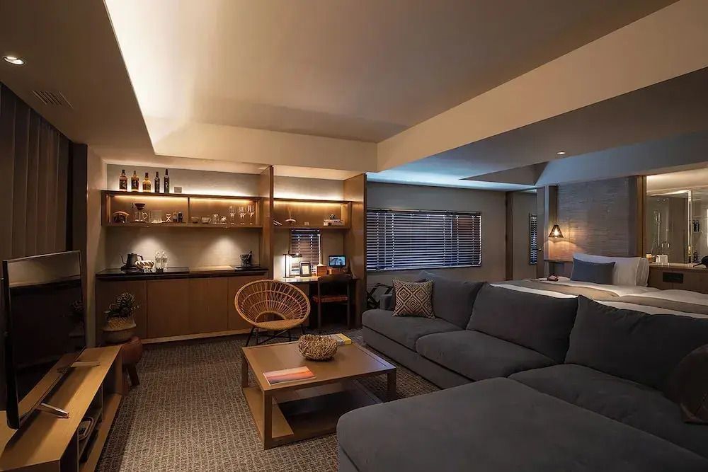 Geräumiges Wohnzimmer mit gemütlichem Sofa, stilvoller Beleuchtung und Annehmlichkeiten.