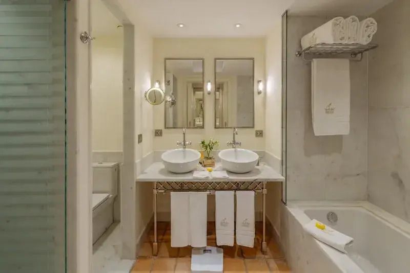 Luxuriöses Badezimmer mit zwei Waschbecken und Badewanne im Bahía del Duque