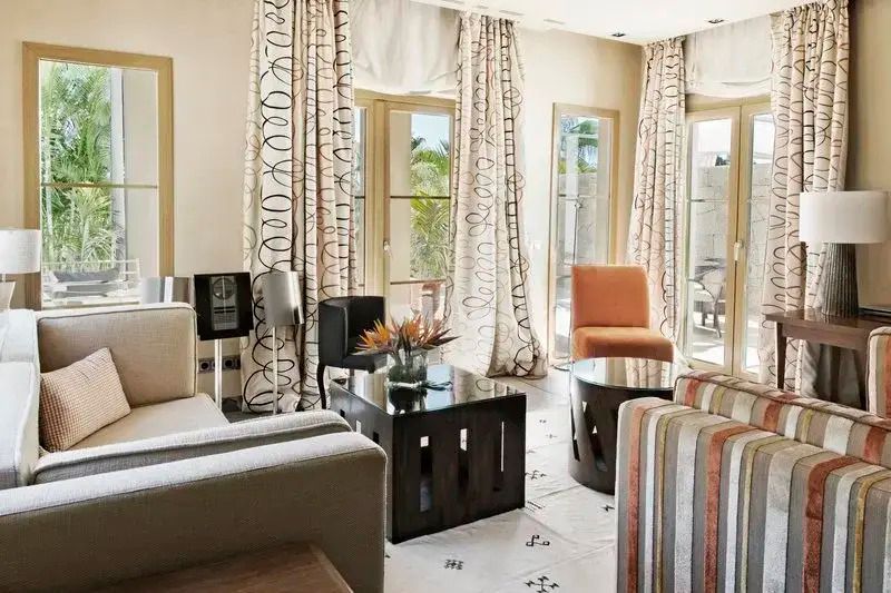Geräumiges Wohnzimmer mit eleganten Sofas und Glasfronten zur Terrasse